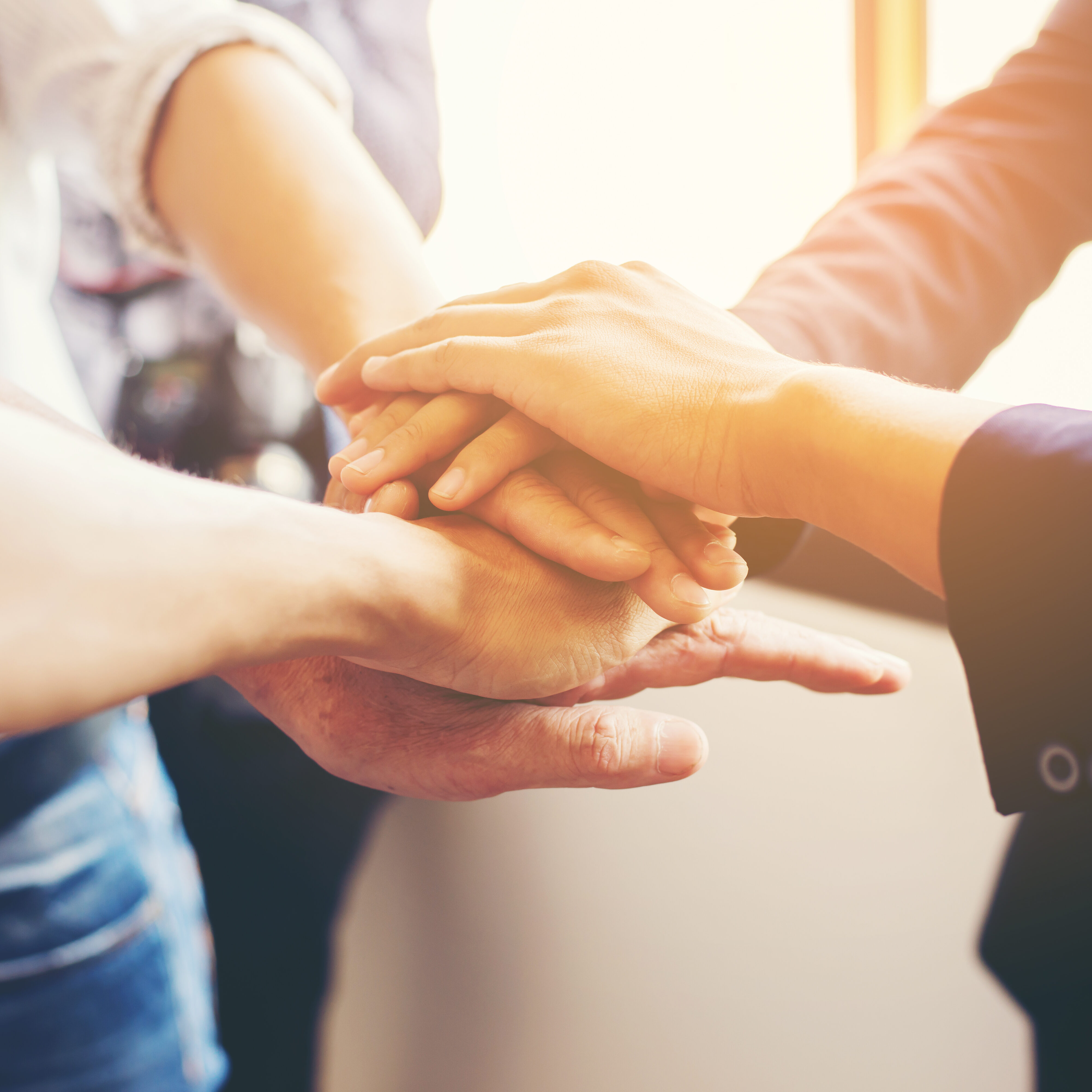 Concept of teamwork: Close-Up of hands business team showing unity with putting their hands together.